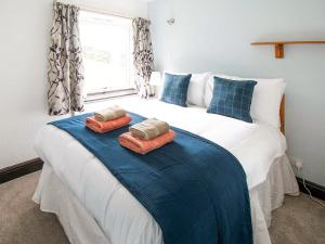 a bedroom with a large bed with two pillows on it at Bramble Cottage- Uk45891 in Farlam