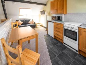 a kitchen and living room with a table and a couch at Alder Cottage - Uk46154 in Farlam