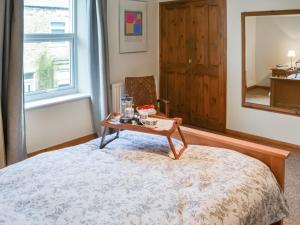 Zimmer mit einem Bett, einem Tisch und einem Spiegel in der Unterkunft Pitmans Cottage in Ryton