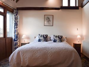 a bedroom with a bed with two pillows on it at Byre Cottage - Meadowbrook Farm in Thame