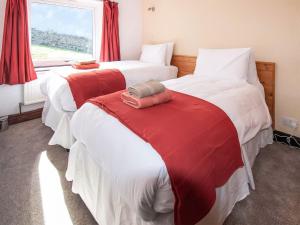 a bedroom with two beds with red and white sheets at Bracken Cottage - Uk46155 in Farlam