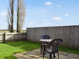 two chairs and a table in a backyard at Byre Cottage - Meadowbrook Farm in Thame