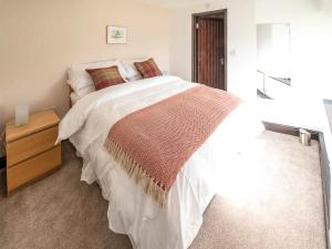 sypialnia z dużym białym łóżkiem i drewnianą komodą w obiekcie Hawthorn Cottage- Uk45890 w mieście Farlam
