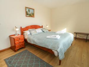 a bedroom with a large bed and a night stand at The Brambles in Wrexham