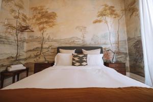 リスボンにあるハウス サン ベントのベッドルーム1室(壁に絵画が描かれた大型ベッド1台付)