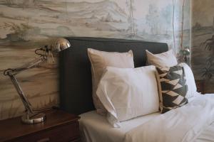 Una cama con almohadas blancas y una lámpara en una mesa. en House Sao Bento en Lisboa