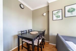 a dining room with a table and chairs and a couch at Bright and Cosy Apartment in South London in London
