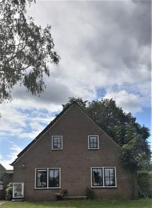 Una casa con cuatro ventanas en la parte superior. en Gastenhuisje, en Zelhem