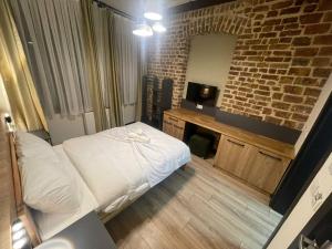 a bedroom with a white bed and a brick wall at Taksim Millennium Alkan Residence in Istanbul