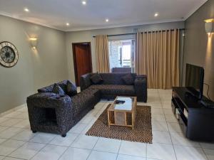 a living room with a couch and a television at Grace Avenue Townhouse in Port Edward