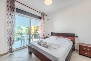 um quarto com uma cama grande e uma janela grande em Coastal Comfort by Premium Selection em Durrës
