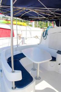 a white table and chairs on a boat at Beau catamaran à la marina in Le Marin