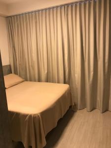 a bedroom with two beds and a curtain at Estúdio perfeito in Curitiba