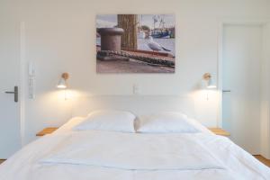 Giường trong phòng chung tại Ferienwohnung Nord-West - direkt am Nordseedeich mit Blick auf den See