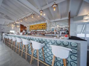 un bar con fila di sgabelli bianchi di B&B HOTEL Fort-de-France a Fort-de-France