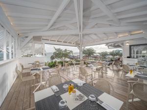 restauracja ze stołami i krzesłami oraz widokiem na ocean w obiekcie B&B HOTEL Fort-de-France w mieście Fort-de-France