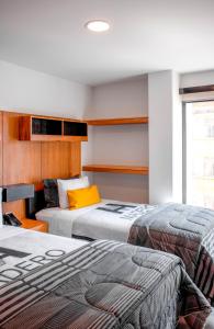 - une chambre avec 2 lits et un oreiller jaune dans l'établissement Madero Hotel & Suites, à La Paz