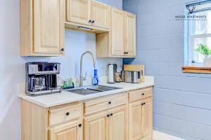 a kitchen with wooden cabinets and a sink at The Moose #3 - Modern Luxe Studio with Free Gated Parking & Wifi in Memphis
