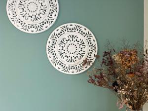 two plates on a wall next to a vase with flowers at Casa Las Pozas in Olite