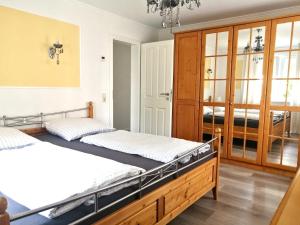two beds in a bedroom with wooden cabinets at Ferienwohnung Rotenfels in Gaggenau