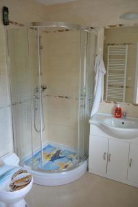 een badkamer met een douche, een toilet en een wastafel bij Béri Apartman in Siófok