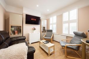 A Stylish Gem with King Beds and WiFi في لندن: غرفة معيشة مع أريكة وكراسي
