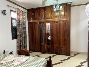 a bedroom with wooden cabinets and a bed in it at Pazuri apartment in Ngambo