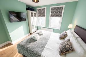 a bedroom with a bed and two windows at A Stylish Gem with King Beds - WiFi & Parking in London