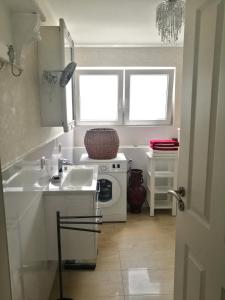 a white kitchen with a sink and a microwave at Ferienwohnung Rotenfels in Gaggenau