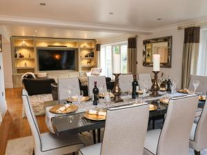 une salle à manger avec une table, des chaises et une télévision dans l'établissement Moor View, à Glossop