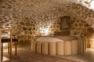 a bedroom with a bed in a stone wall at Ana Talia House in Mardin