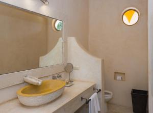 W łazience znajduje się drewniana umywalka i lustro. w obiekcie Hotel Hacienda Ticum w mieście Ekmul