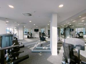 a gym with treadmills and ellipticals in a building at Snuggle Inn - Riverside Apartments - Views Over looking London River Thames, Close to O2 Arena, London Excel, London City Airport, Thames Clipper- River Boat Service, Woolwich Ferry, with onsite parking in London