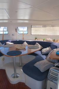 a room with a table and couches in a boat at Cabine d'un catamaran privatisé in Le Marin