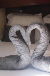 a pair of towels forming a heart on a bed at Cabine d'un catamaran privatisé in Le Marin