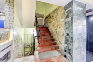 - un escalier dans une maison avec un mur en briques dans l'établissement OYO Sam Guest House, à Chennai