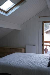 una camera con un letto bianco e una finestra di Appartement avec vue et jardin a Formiguères