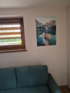 - un salon avec un canapé et une photo sur le mur dans l'établissement Willa Anna, à Zakopane