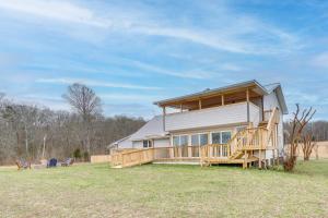 una casa grande con una gran terraza en un campo en Riverfront Dayton Getaway on 700 Wooded Acres!, en Dayton