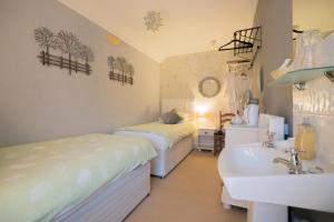 a bathroom with two beds and a sink and a tub at Maison Dieu Guest House in Dover