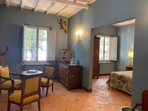 - une chambre avec un lit, une table et des chaises dans l'établissement Villa Cosmiana Wine estate, l'appartement du régisseur du domaine, à Peccioli