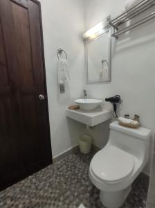 a bathroom with a white toilet and a sink at Quinta Rosita in Ticul