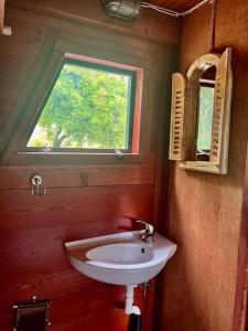a bathroom with a sink and a window at A-frame off the grid in Khalikerí