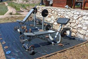 a group of exercise equipment on top of a stone wall at A-frame off the grid in Khalikerí
