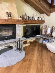 a living room with a fireplace and a television at Miramountains in La Thuile