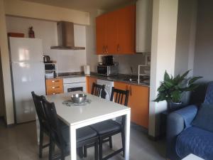 a kitchen with a white table and chairs and a blue couch at Céntrico apartamento en Corrubedo in Corrubedo