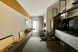 a kitchen with black and white cabinets and a living room at My Studio in Franca