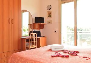 een slaapkamer met een bed en een bureau met een computer bij Hotel Bamar in Cervia