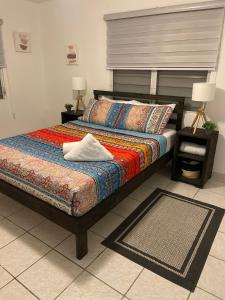 a bedroom with a bed with a colorful comforter at Cozy Cute Home 2nd floor in Fajardo