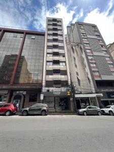 ein hohes Gebäude mit davor geparkt in der Unterkunft Master Express Alberto Bins - 200 metros do Hospital Santa Casa in Porto Alegre